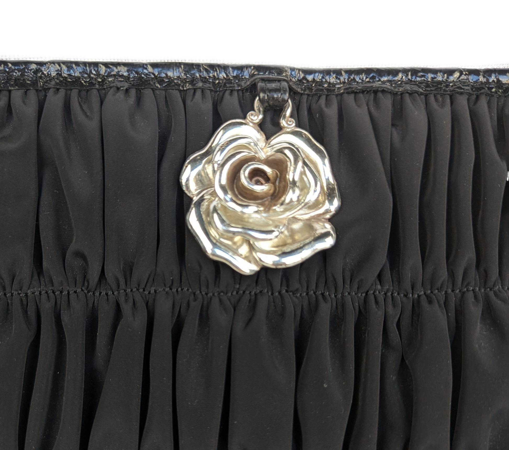 Brighton Black Ruched Nylon Evening Bag with heavy, silver rose detail adorning the front! This is a perfect evening bag to fit all your essentials. It has extra room for lipstPurse, handbagBrighton Black Ruched Nylon Evening BagBrighton Black Ruched Nylon Evening Bag
