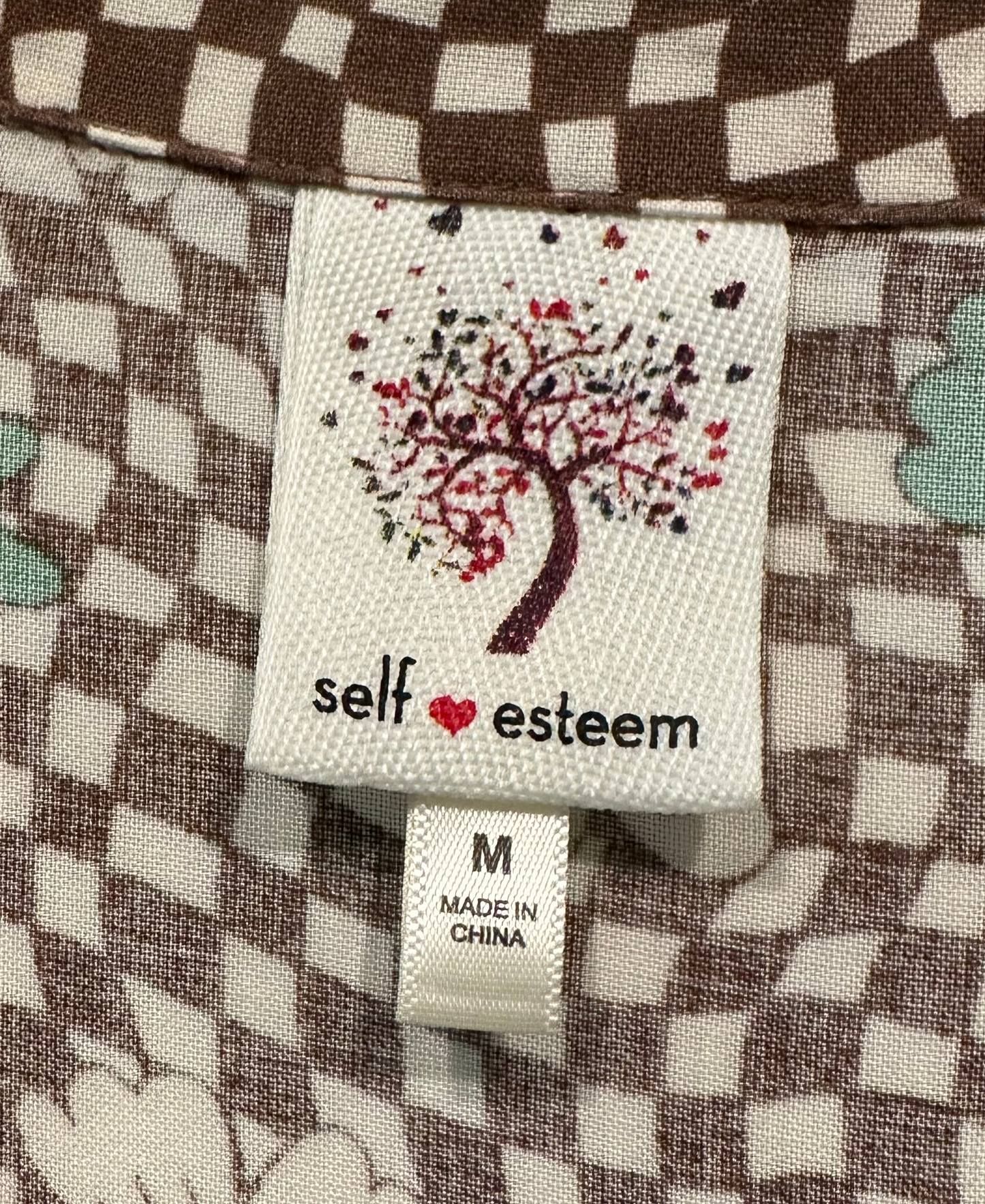 SSelf Esteem Short Sleeve Retro Floral Print Blouse is a vintage wardrobe must-have! With its funky retro floral and checker print in earthy green and brown hues, you'll exude confShirtSelf Esteem Short Sleeve Retro Floral Print BlouseEsteem Short Sleeve Retro Floral Print Blouse