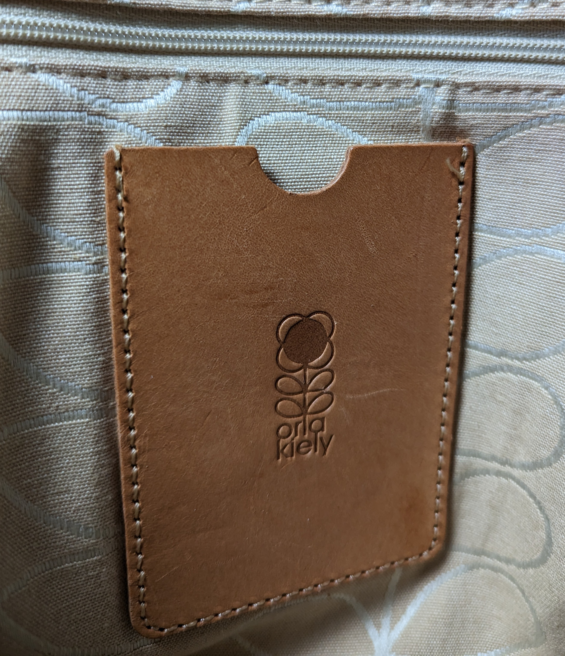 Orla Kiely Rare Mustard Forget-Me-Not Shoulder BagThis bag has such style. It is coated canvas and in excellent condition.  There is some discoloration along the top edge, and on the bottom seam that is detailed in Orla Kiely Rare Mustard Forget-Handbag