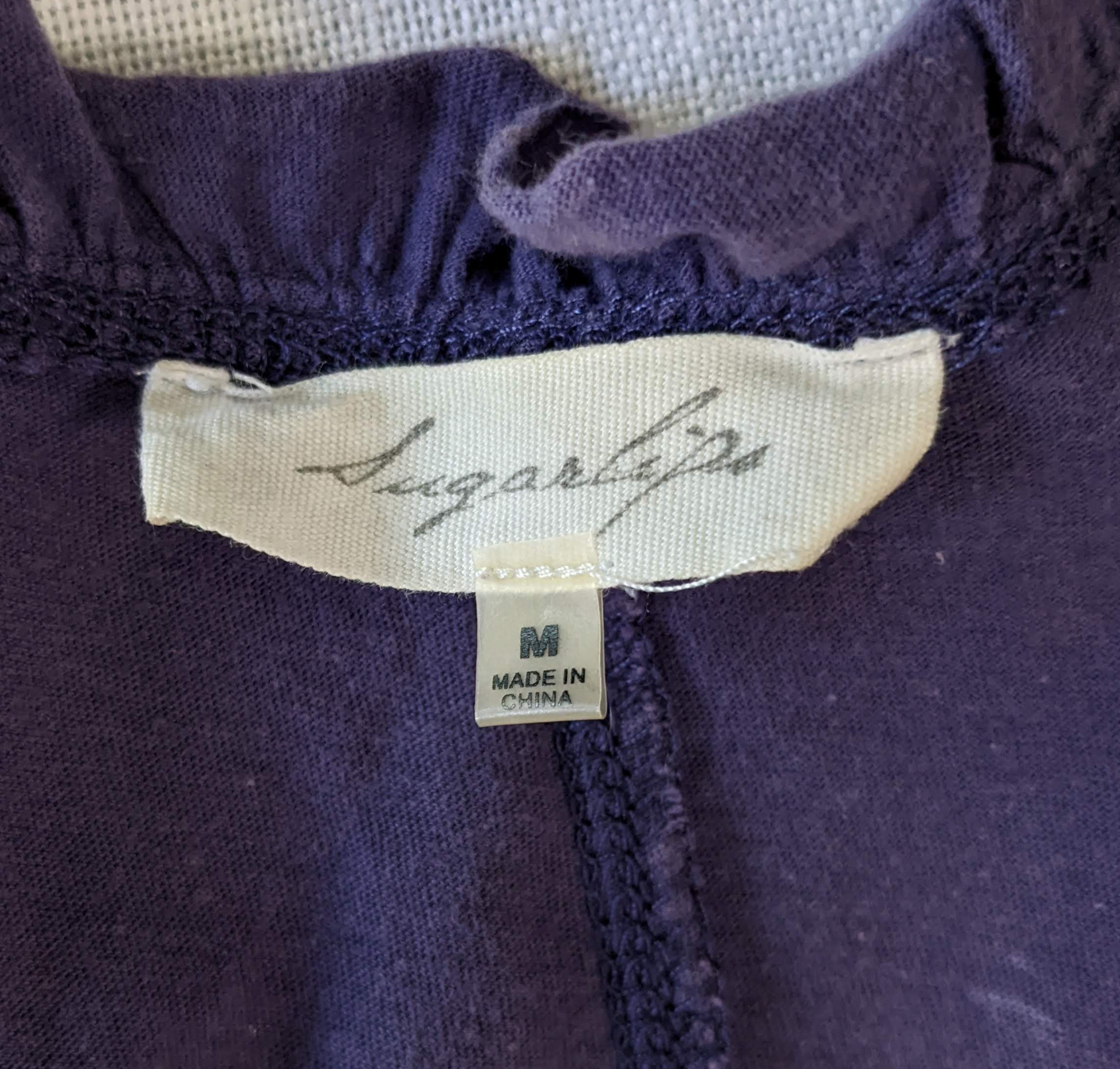 Sugarlips Purple Ruffle-neck Flowy Tank Let your style be the sweetest with the Sugarlips Purple Ruffle-neck Flowy Tank. This racerback tank is made from a soft, flo