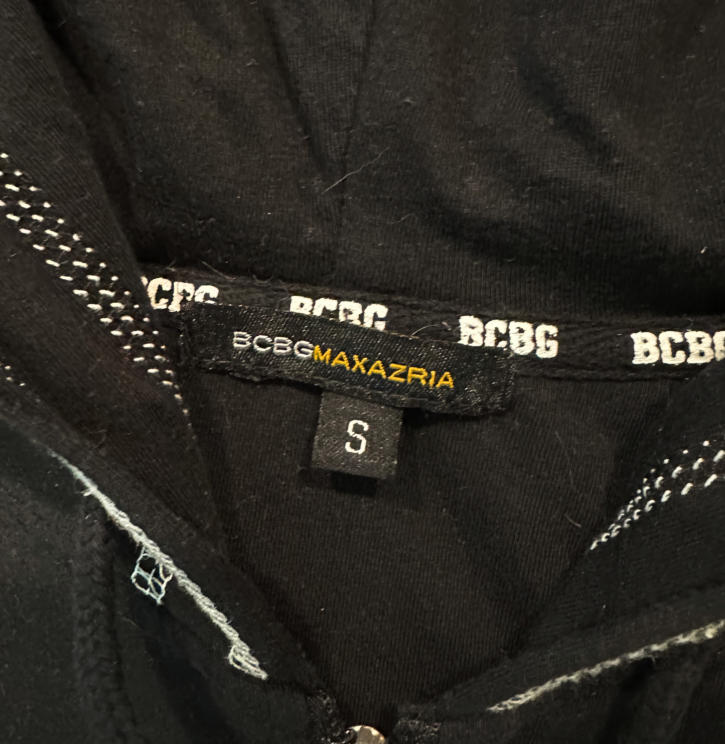 BCBGeneration Black Zip-Up Hoodie with White StitchingSlip into something cozy and chic! The BCBGeneration Black Zip-Up Hoodie with White Stitching is the perfect addition to your wardrobe, combining go-to style with a BCBGeneration Black Zip-Hoodie