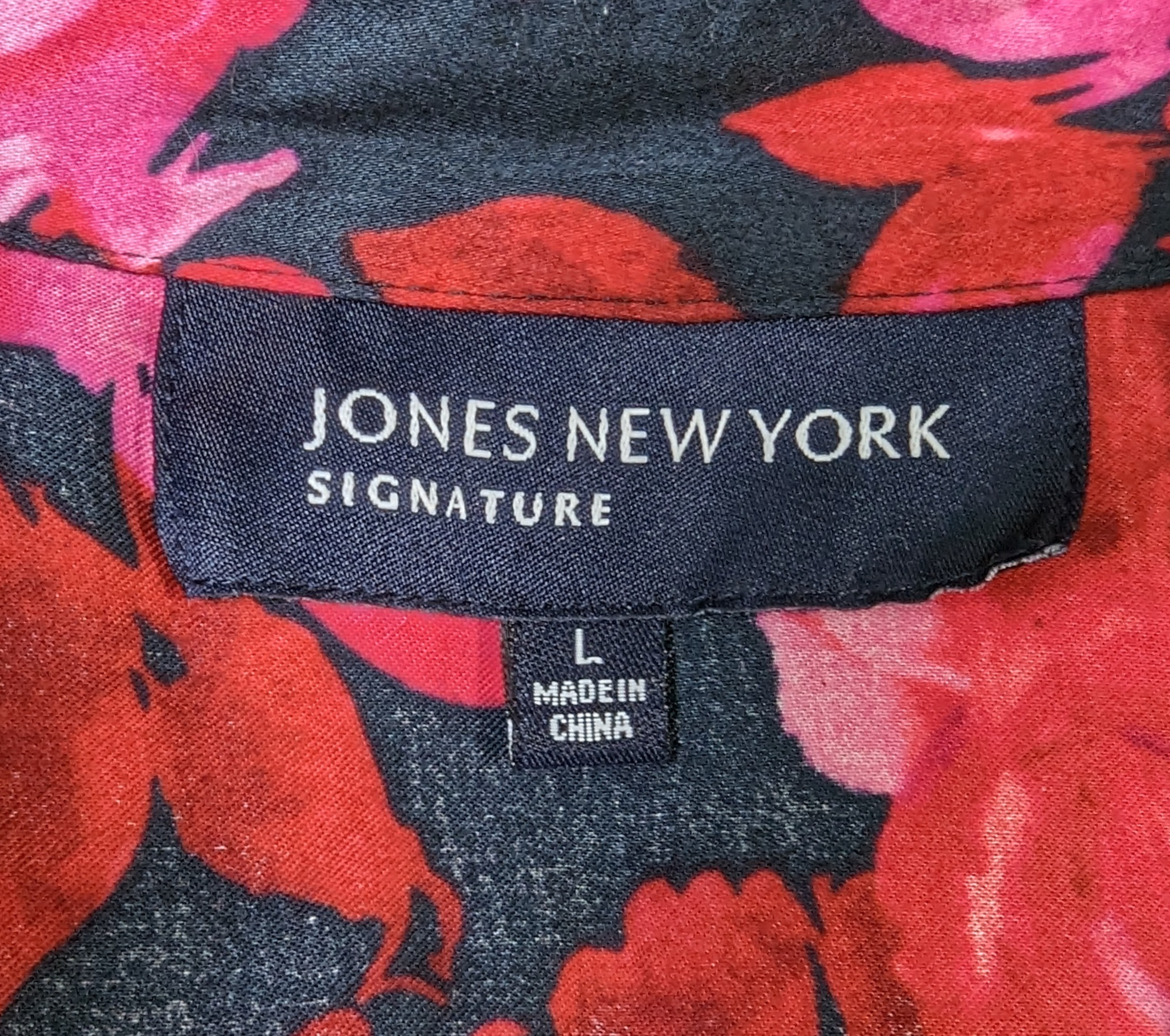 Jones New York SignatureLook your best in the Jones New York Ruffle Neck Blouse! With a black base and a pink and red floral print, this blouse is perfect for making a statement. The ruffleBlouseJones New York Ruffle Neck BlouseYork Ruffle Neck Blouse