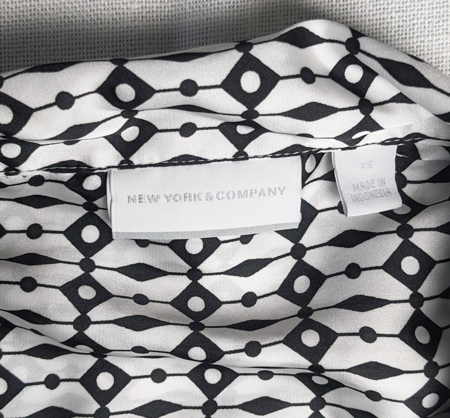 New York & Co Black and White Sleeveless Blouse This is a great top to dress down with jeans, or dress up with black slacks.  Or try a pop of color and wear with a g